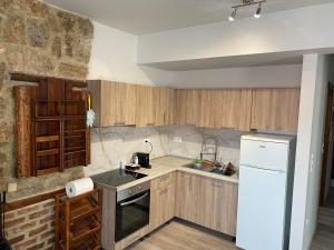 a kitchen with wooden cabinets and a white refrigerator at TM Apartment No 1 - Rustic Style in Aridaia