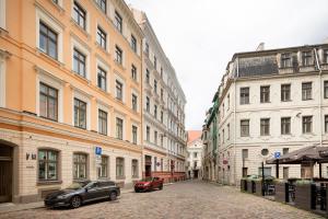 a street with two cars parked in front of buildings at Old Riga Modern and Spacious 2 bedroom Apartment in Rīga