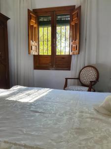 - une chambre avec un lit, une fenêtre et une chaise dans l'établissement Carmen de la Sultana, à Grenade