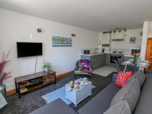 ein Wohnzimmer mit Couch und Küche in der Unterkunft The Little Cottage in Weymouth