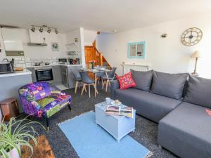 ein Wohnzimmer mit Sofa und Tisch in der Unterkunft The Little Cottage in Weymouth
