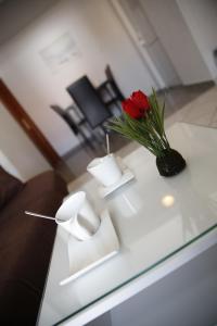 una rosa rossa in un vaso su un tavolo di vetro di Apartments Lepur a Vodice