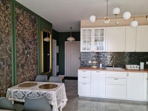 a kitchen with white cabinets and a table at Apartament na Wzgórzu Zielony in Łańcut