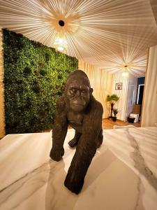 a statue of a gorilla sitting on a bed at A Fleur de Spa : Maison chaleureuse avec spa privatif et billard. in Coulogne