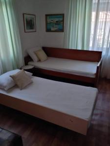 2 Betten in einem Zimmer mit Vorhängen in der Unterkunft Aegean blue in Kallirákhi