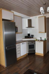 a kitchen with a black refrigerator and white cabinets at Saimaa Seasons Marina Villas in Imatra
