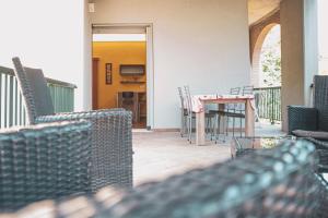un patio con sedie, tavolo e sedie di Il Mughetto - Appartamento con Terrazza Privata a San Quirico dʼOrcia