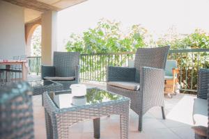 patio con sedie in vimini e tavolino di Il Mughetto - Appartamento con Terrazza Privata a San Quirico dʼOrcia