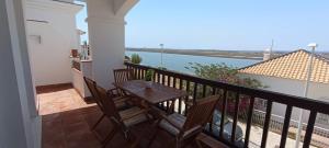 a balcony with a table and chairs and a view of the ocean at Dúplex Mirador del Guadiana in Ayamonte