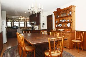 uma cozinha com uma mesa de madeira e cadeiras em Wahoo by Oak Island Accommodations em Oak Island
