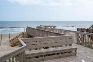 a wooden boardwalk leading to the beach with the ocean at Wahoo by Oak Island Accommodations in Oak Island