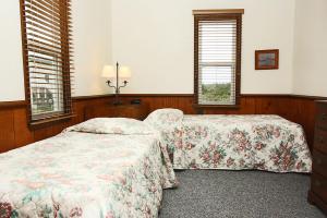a bedroom with two beds and two windows at Wahoo by Oak Island Accommodations in Oak Island
