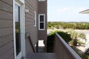 a house with a staircase leading up to a porch at Wahoo by Oak Island Accommodations in Oak Island