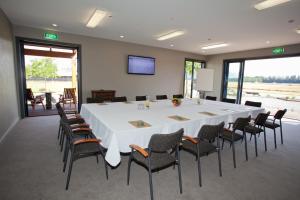 uma grande sala de reuniões com uma grande mesa branca e cadeiras em Ski Time em Methven