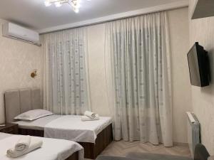 Habitación hospitalaria con 2 camas y TV en Home Plus Apartments en Tiflis