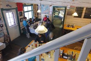 a group of people sitting at tables in a restaurant at Talkeetna Roadhouse in Talkeetna