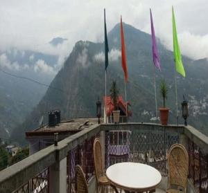 a table and chairs on a balcony with flags at Devbhoomi by StayApart in Ukhimath +6 photos