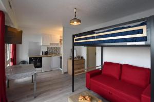 a living room with a red couch and a loft bed at Le P'tit bec ✹ Plage ✹ in Saint-Hilaire-de-Riez
