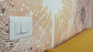 a white lightswitch on a wall with a flower pattern at Luce Marmore in Le Marmore
