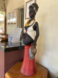une statue d'une femme enceinte assise sur une table dans l'établissement Pousada Paraiso, à Santo Amaro
