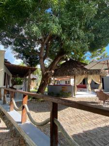 a tree in front of a house with a fence at Pousada Paraiso in Santo Amaro