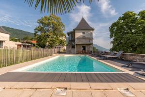 a swimming pool in front of a house at Les Tours Carrées in La Motte-Servolex