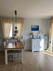 a dining room with a wooden table and chairs at Haus Luca Fuhlendorf in Fuhlendorf