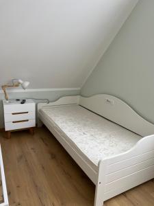 a small bedroom with a bed and a nightstand at Haus Luca Fuhlendorf in Fuhlendorf