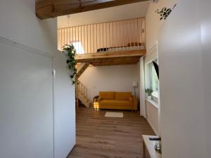 a hallway with a yellow couch in a room at Dowiośnie in Wiele