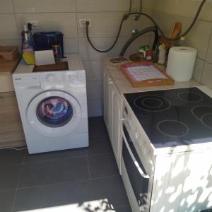 een keuken met een wasmachine en een fornuis bij Auto camp Radoman in Virpazar