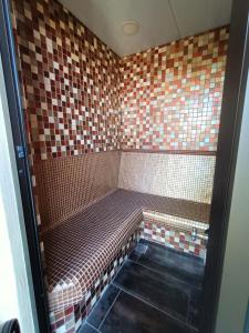 a tiled shower with a bench in a bathroom at Einzigartiges Spa Resort für Ruhe und Entspannung bis 8 Personen in La Orotava
