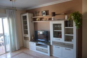 a living room with a entertainment center with a tv at Irene Beach Málaga, Parking Gratuito in Cala del Moral