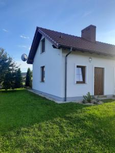 a white house with a green yard at Apartament w Chęcinach in Chęciny