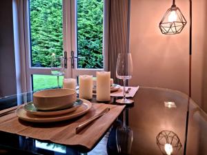 a dining room with a table with plates and glasses at Park View Garden apartment in Salfords