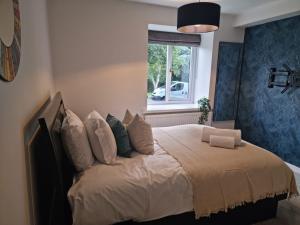 a bedroom with a large bed with a window at Park View Garden apartment in Salfords