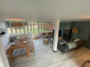 ein Wohnzimmer mit einem Tisch und einem Sofa in der Unterkunft Maison de campagne entièrement climatisée avec grand jardin in Pressagny l'Orgueilleux