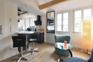 a living room with chairs and a table and a kitchen at Das schiefe Haus - Wohnung "Weinlage" in Heppenheim an der Bergstrasse +6 photos