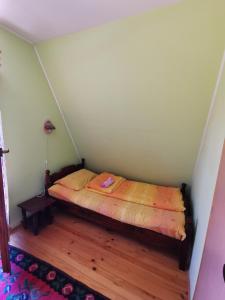 a small bed in a corner of a room at Vikendica Dana in Mitrovac