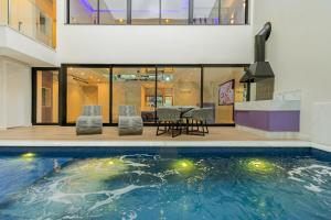 a house with a swimming pool with a table and chairs at Poeme Motel by Drops in São José dos Pinhais