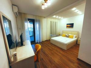 a bedroom with a bed and a desk with a television at Casa Maria Mamaia Nord in Mamaia Sat/Năvodari
