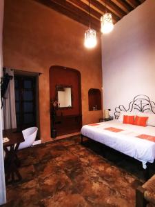 een slaapkamer met een bed, een tafel en een spiegel bij Hotel Boutique Casona Cantera Querétaro in Querétaro