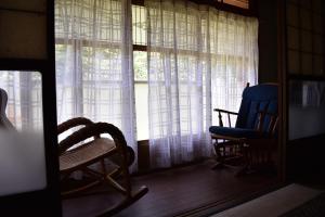 um quarto com duas cadeiras e uma janela com cortinas em Guest House Miei - Vacation STAY 87536v em Nagahama