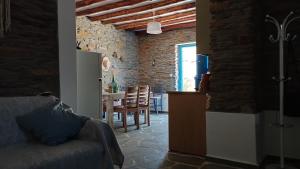 Il comprend une cuisine et un salon avec une table et des chaises. dans l'établissement Villa Kalamonari nature house, cycladic wilderness, à Rogón