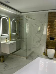 a bathroom with a shower and a sink and a toilet at Apartament "Prezydencki" Centrum z dużą wanną dla Dwojga in Gniezno