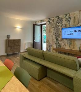uma sala de estar com um sofá e uma televisão de ecrã plano em Silos Torrenova suite em Potenza Picena