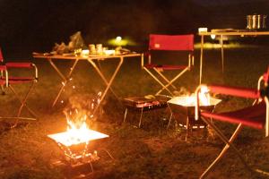 佐渡市にあるguesthouse UZU Sado - Vacation STAY 90684vの夜のキャンプファイヤーの周りにテーブルと椅子