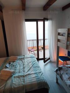 a bedroom with a bed and a view of the ocean at Počitniška hiša Morski pogled in Mošćenička Draga