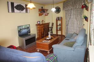 a living room with two blue couches and a television at Apartamento Centro Murcia in Murcia