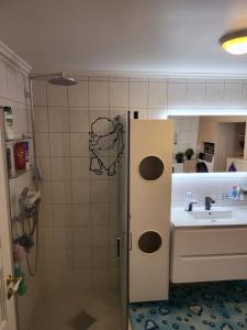 a small bathroom with a sink and a shower at Sentrumsleilighet med gratis parkering til leie in Arendal