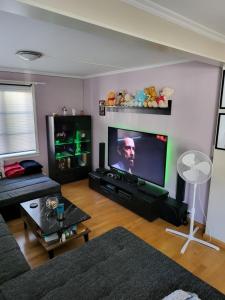 a living room with a large flat screen tv at Sentrumsleilighet med gratis parkering til leie in Arendal